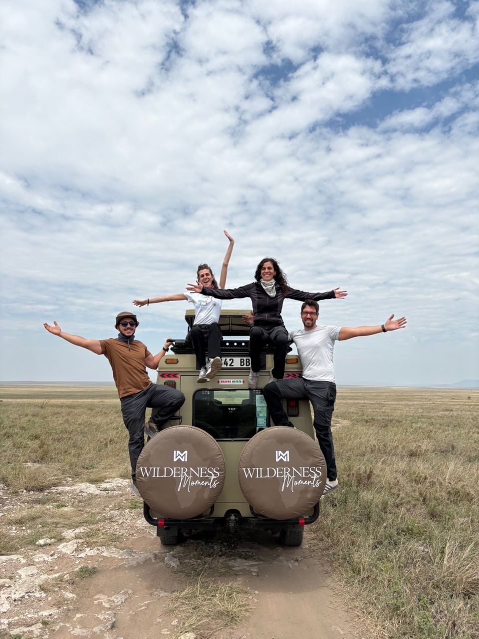 Guests celebrating on the Wilderness Moments safari vehicle in the Serengeti